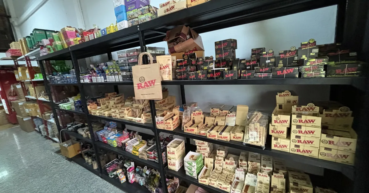 Shop shelves stacked with boxes of rolling papers, grinders and smoking accessories