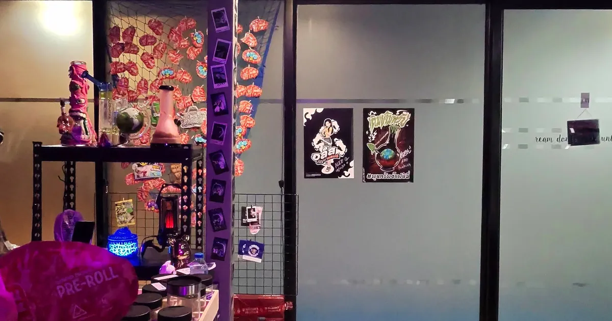 Shop corner with colourful glass pieces and neon decor beside frosted glass and two framed posters