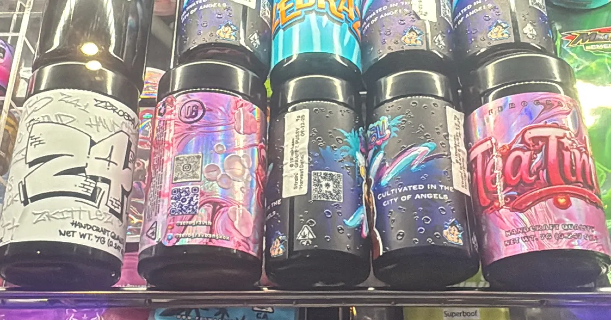 Five jars with bold graphic labels lined up on a lit shop shelf